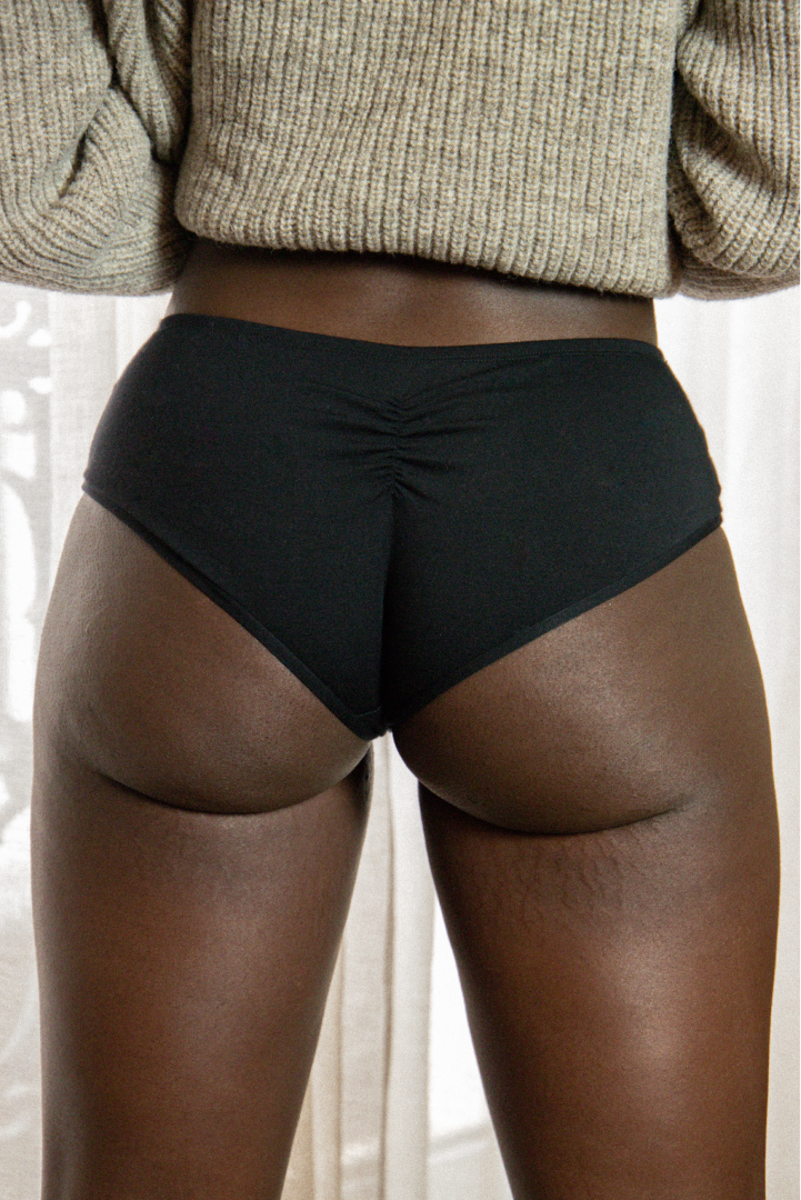 plan rapproché d'une femme noire de dos en shorty avec une couture au milieu des fesses sexy
